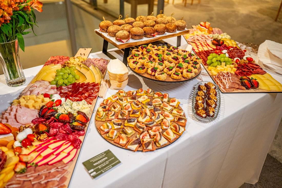 Mesa gastronômica da Valentina com grande volume de tábuas, canapés e acompanhamentos