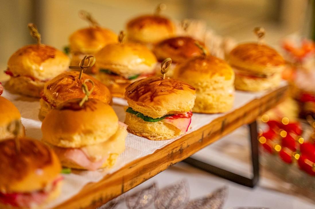 Mini sanduíches produzidos pela Valentina, servidos em tábua de madeira