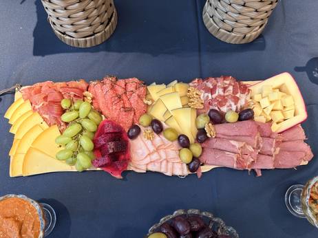 Close da tábua com presunto cru, queijos, uvas e frutas